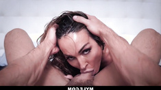 A sensual older woman named Aubrey, with dark hair, is shown experiencing ejaculation inside her sheer leotard.